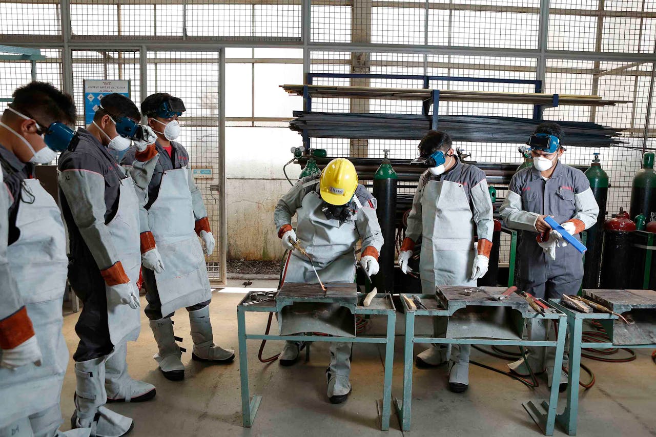 hero-img-02 Group of workers in protective gear engaged in factory training in the Philippines.